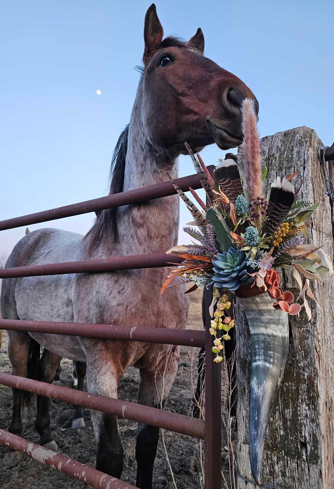 Horse standing behind a fence with floral decorations