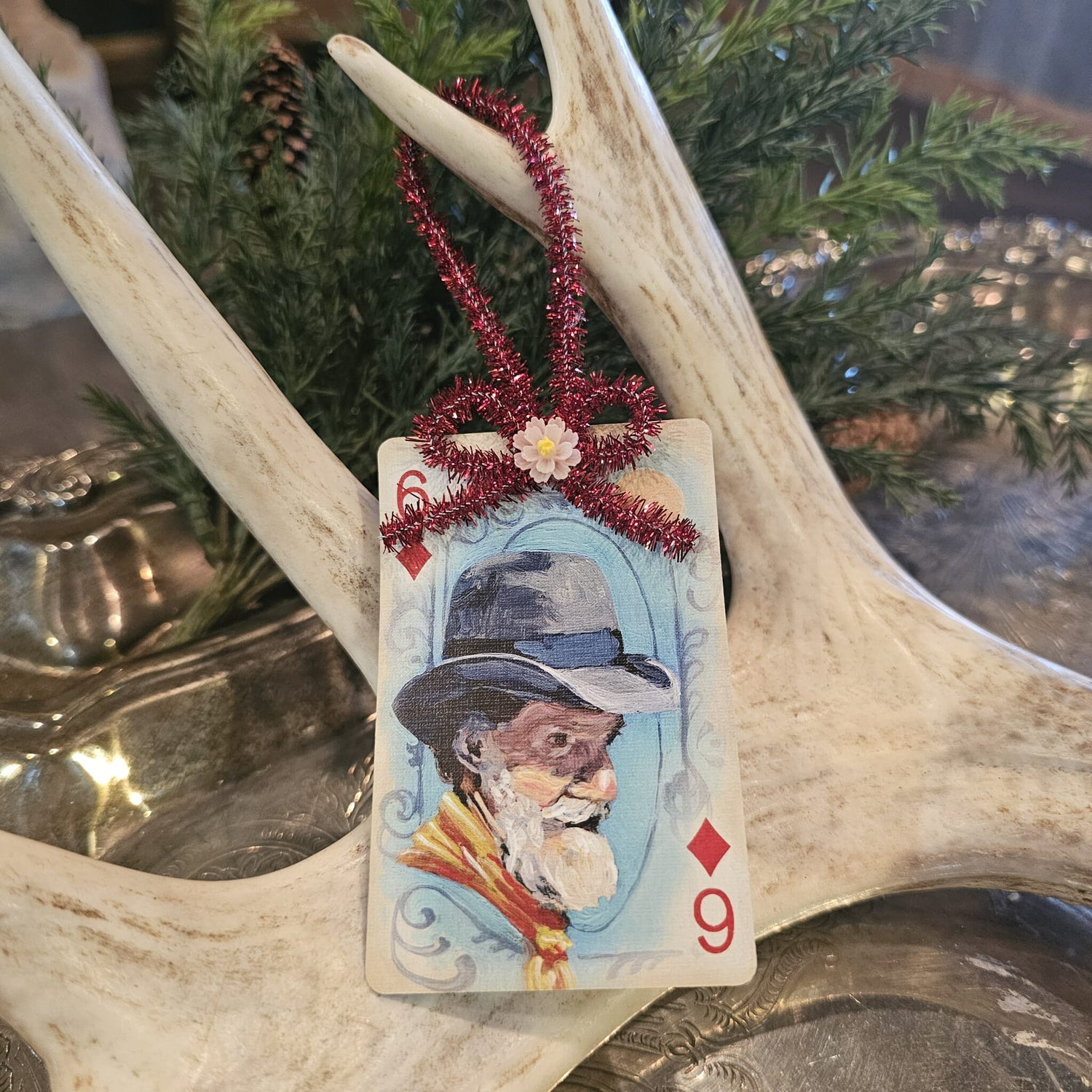 Vintage style cowboy playing card Christmas ornament hanging on an antler