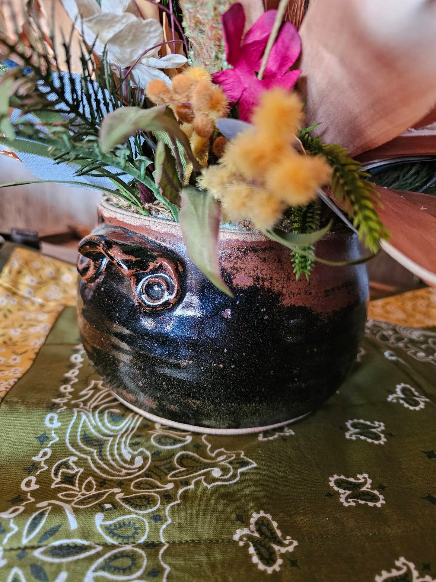 Decorative pot with flowers on a patterned tablecloth
