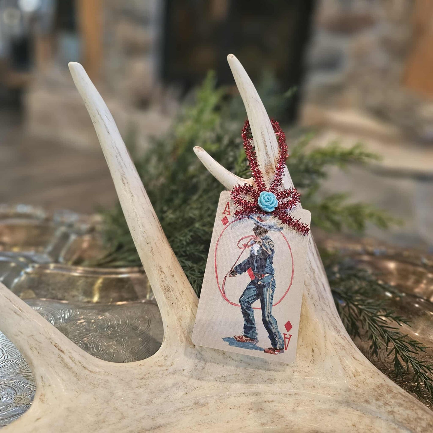 Vintage style cowboy and rope playing card Christmas ornament hanging on an antler