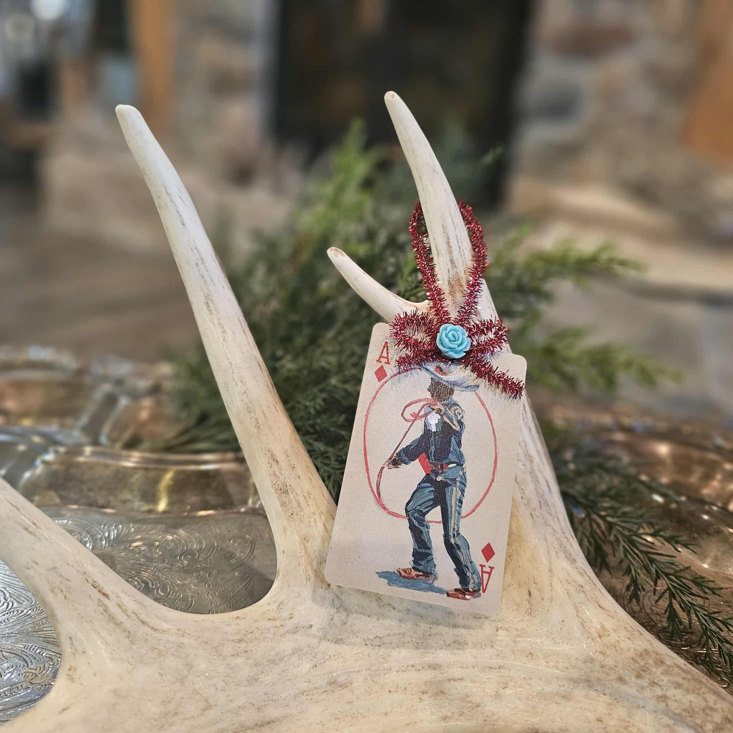 Vintage style cowboy and rope playing card Christmas ornament hanging on an antler
