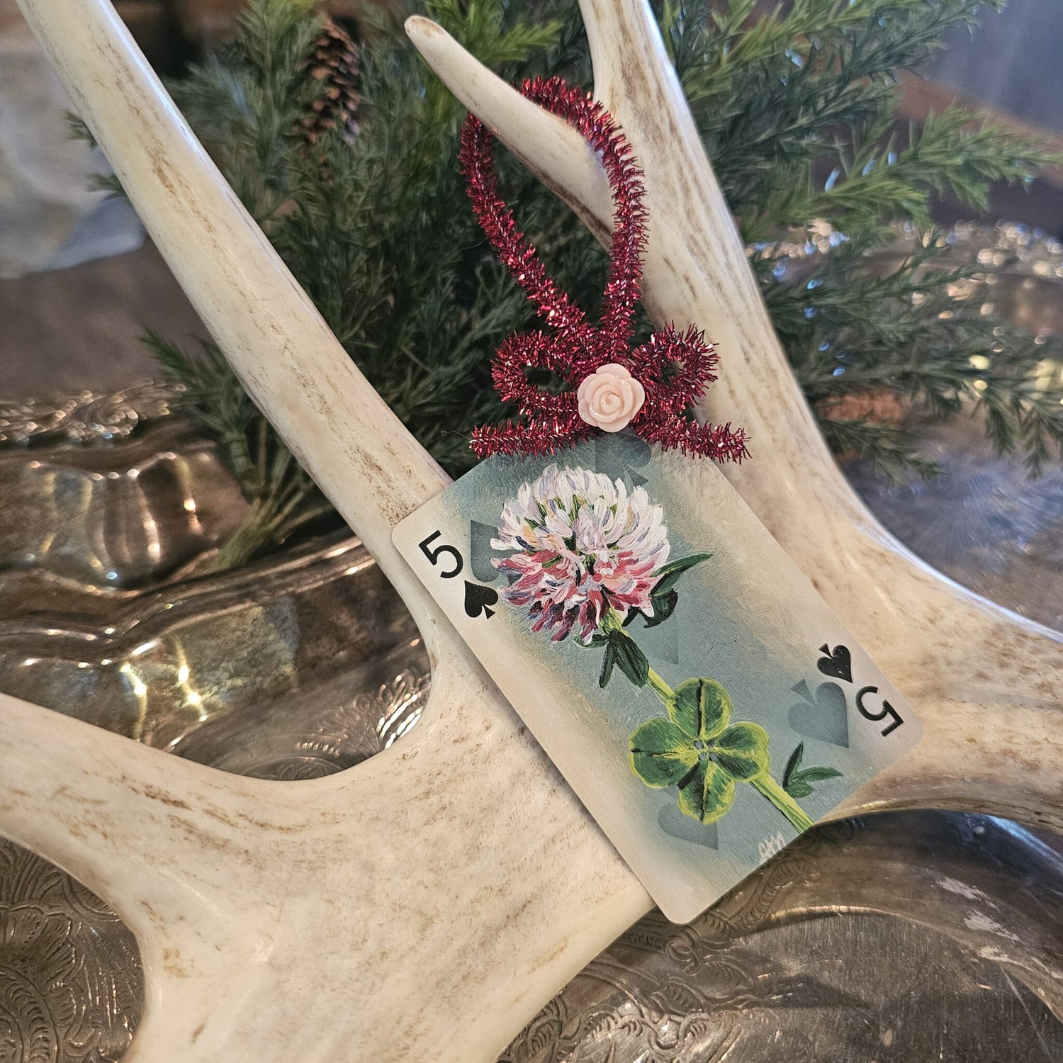 Vintage style clover playing card Christmas ornament hanging on an antler