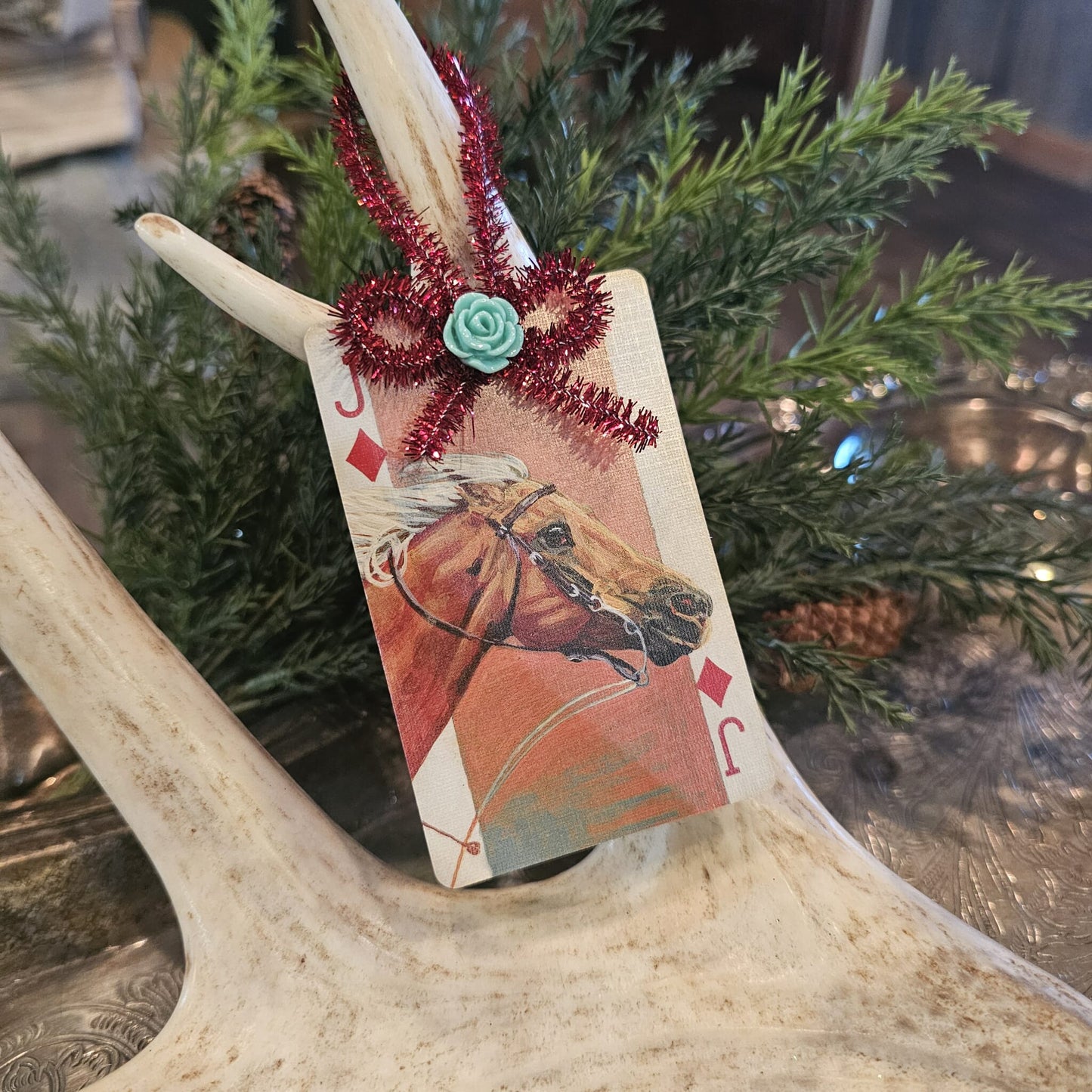 Vintage style racing horse playing card Christmas ornament hanging on an antler