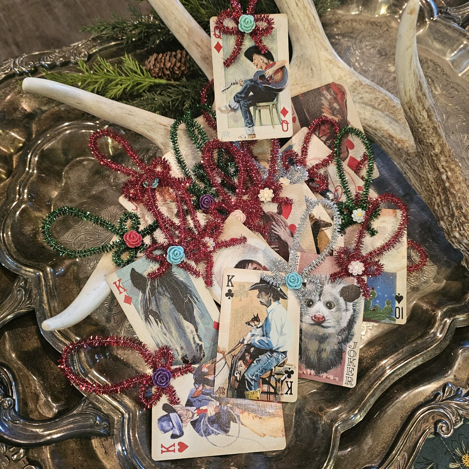 Vintage playing card ornaments in a silver tray with an antler
