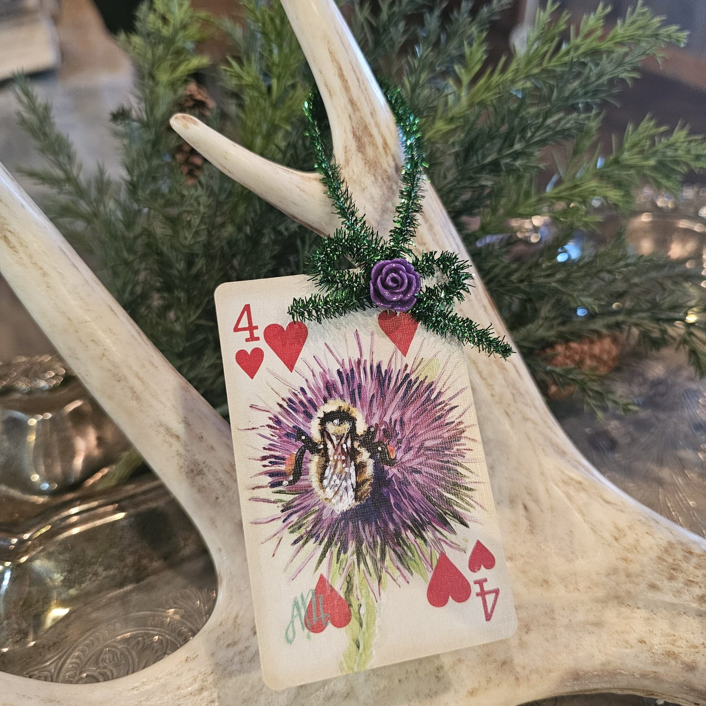 Vintage style flower and bee playing card Christmas ornament hanging on an antler