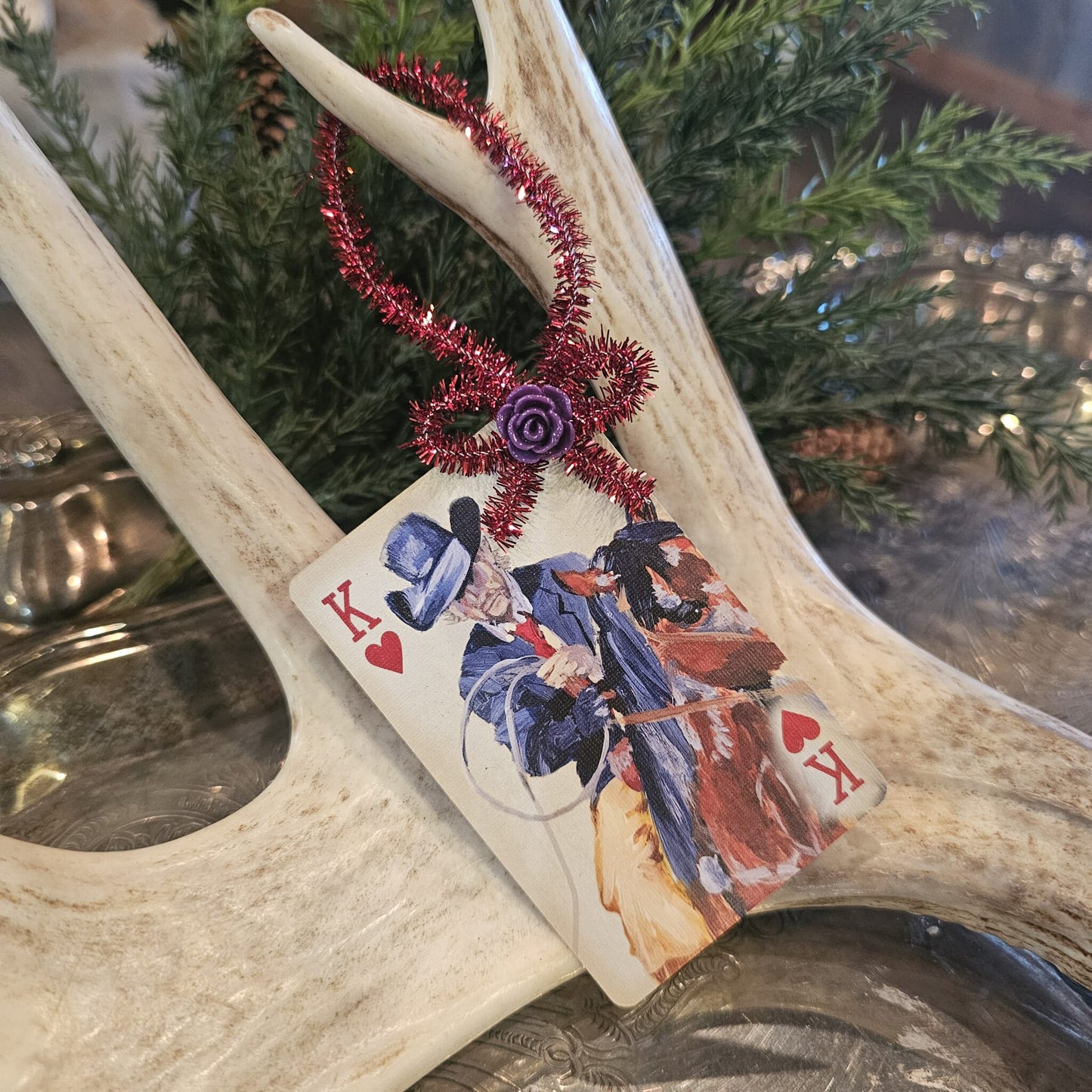 Vintage style cowboy riding in a suit playing card Christmas ornament hanging on an antler