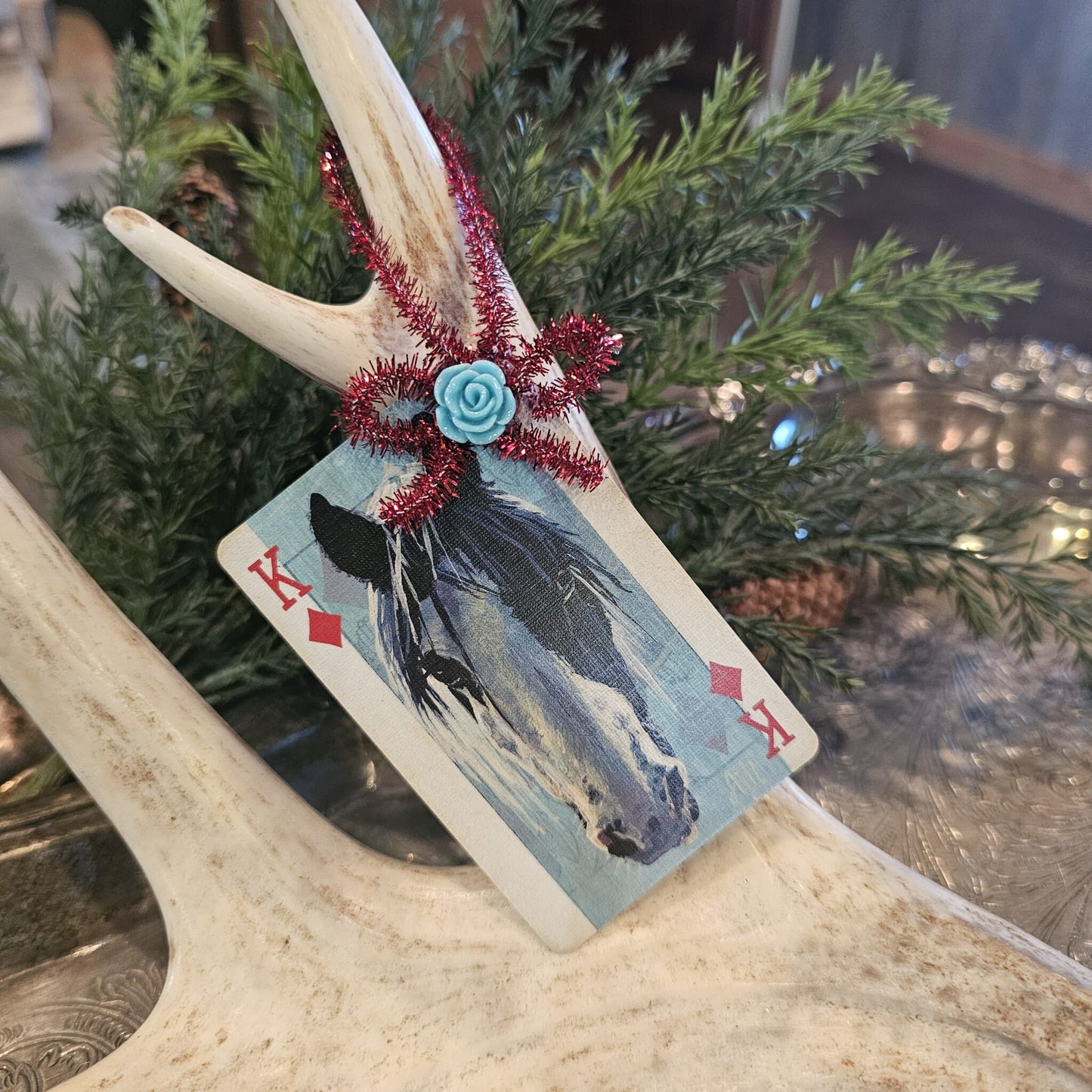 Vintage style horse playing card Christmas ornament hanging on an antler