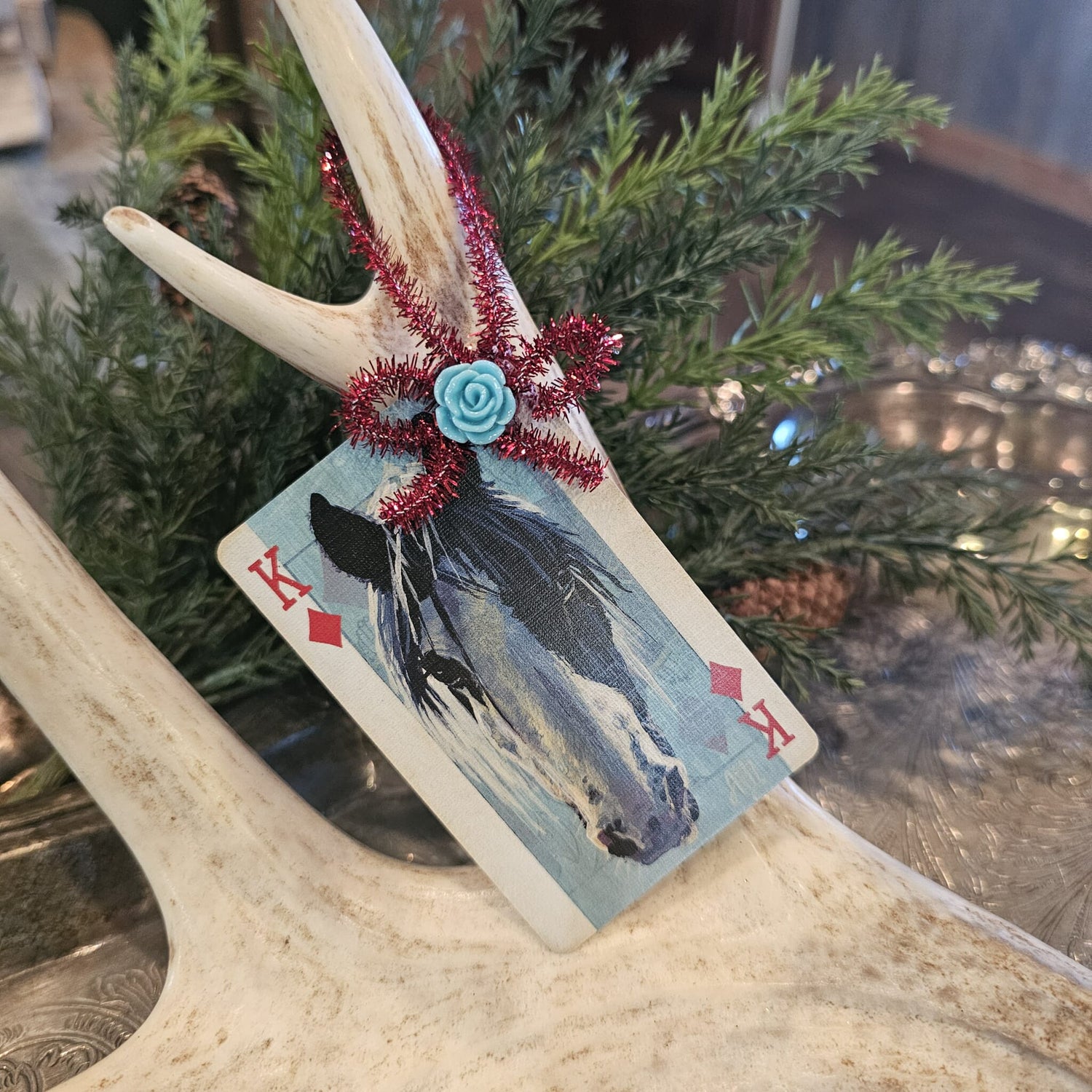 Vintage style horse playing card Christmas ornament hanging on an antler