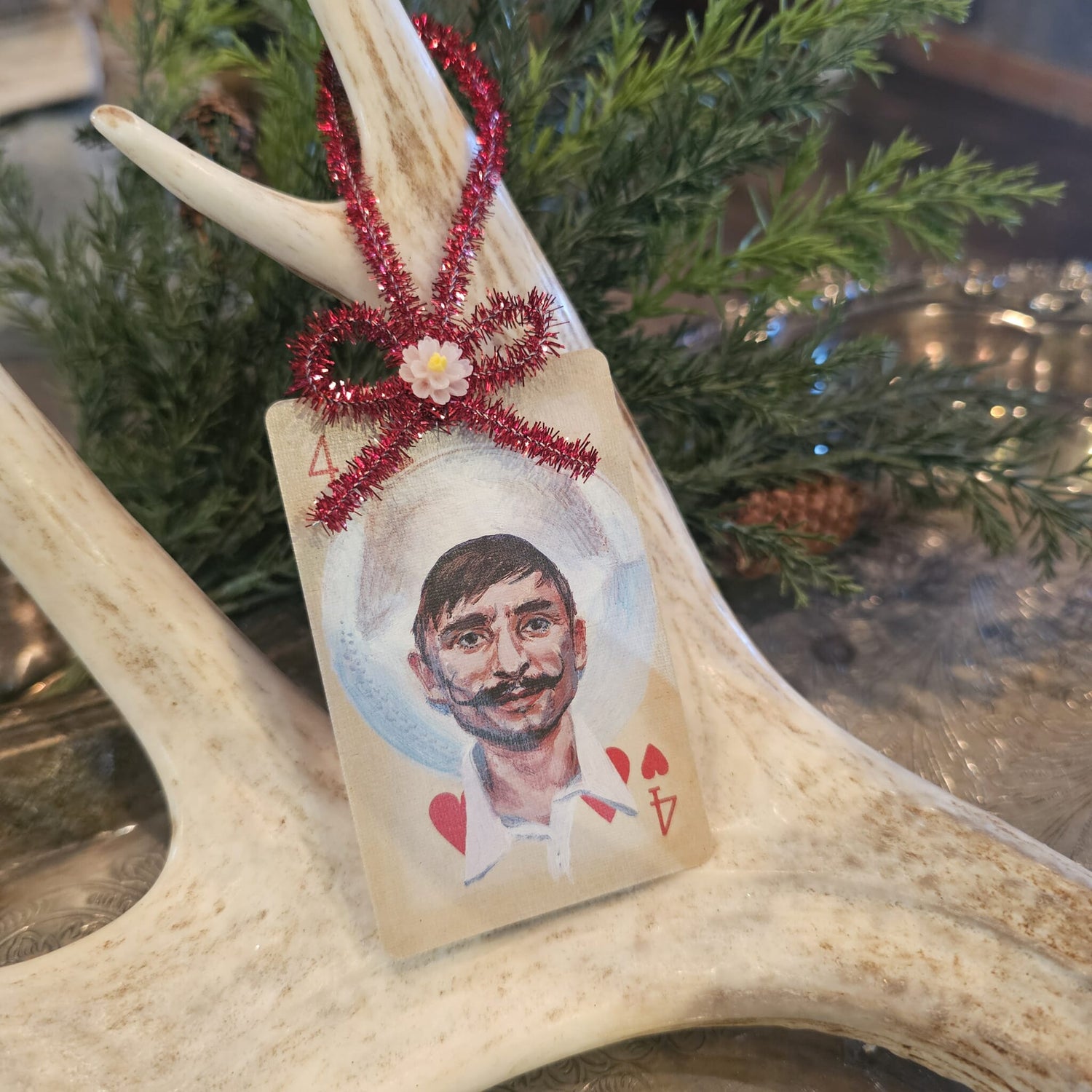 Vintage style cowboy with a mustache playing card Christmas ornament hanging on an antler