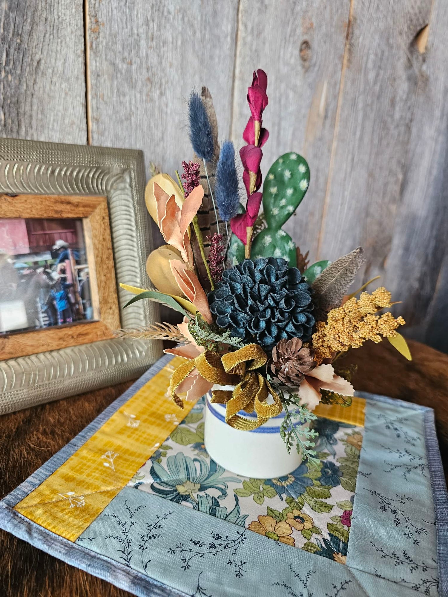 Decorative floral arrangement in a vase on a table with a wooden background