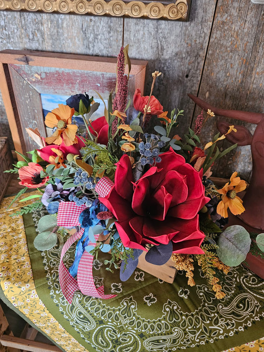 Colorful floral arrangement on a wooden table with a rustic background
