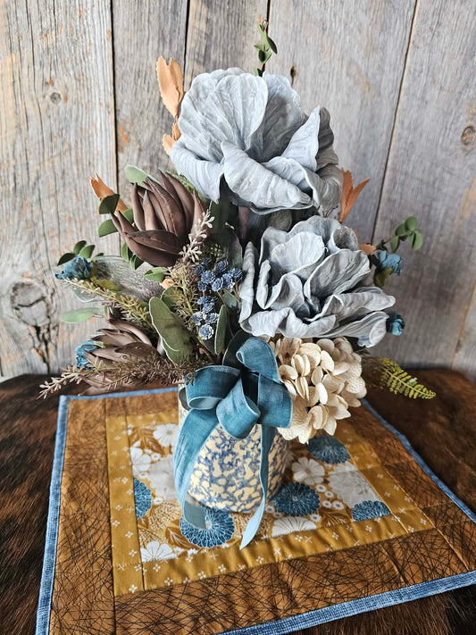 Decorative floral arrangement on a wooden table with a rustic background
